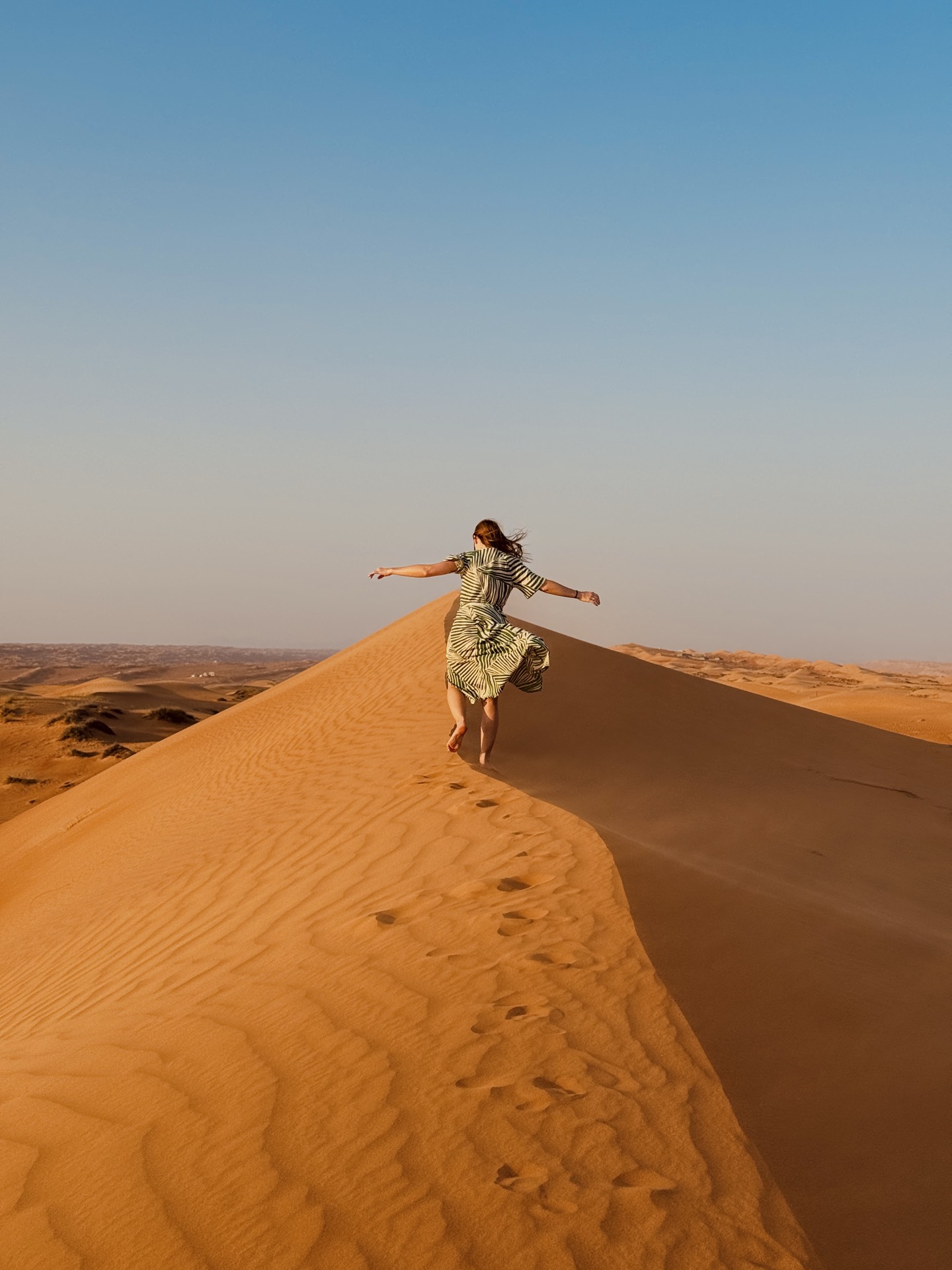 Running along a dune ridge in the Wahiba desert, Oman